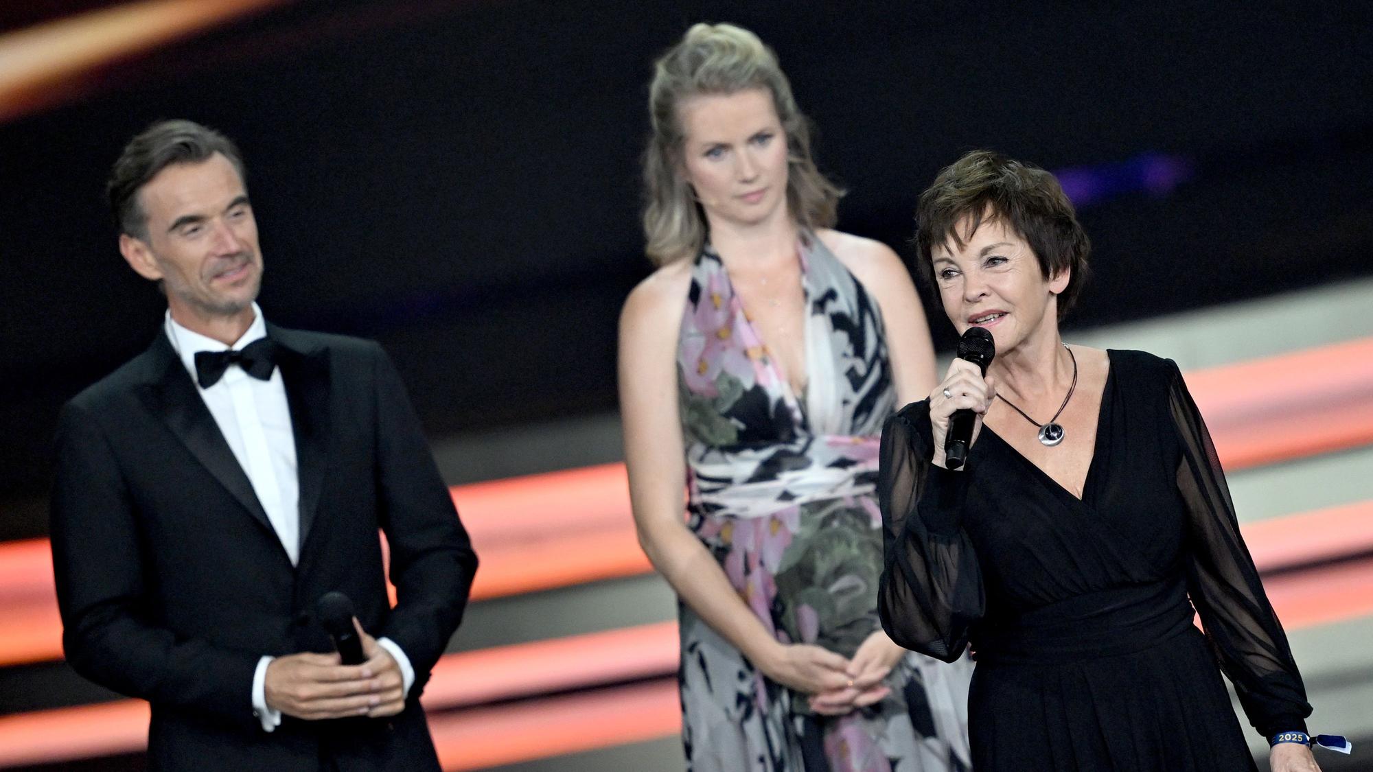 Katrin Sass (vorn) bedankt sich bei der Verleihung des Medienpreises „Goldene Henne“ vor Laudatorin und „Tatort“-Star Cornelia Gröschel und Moderator Florian Silbereisen über den Ehrenpreis.