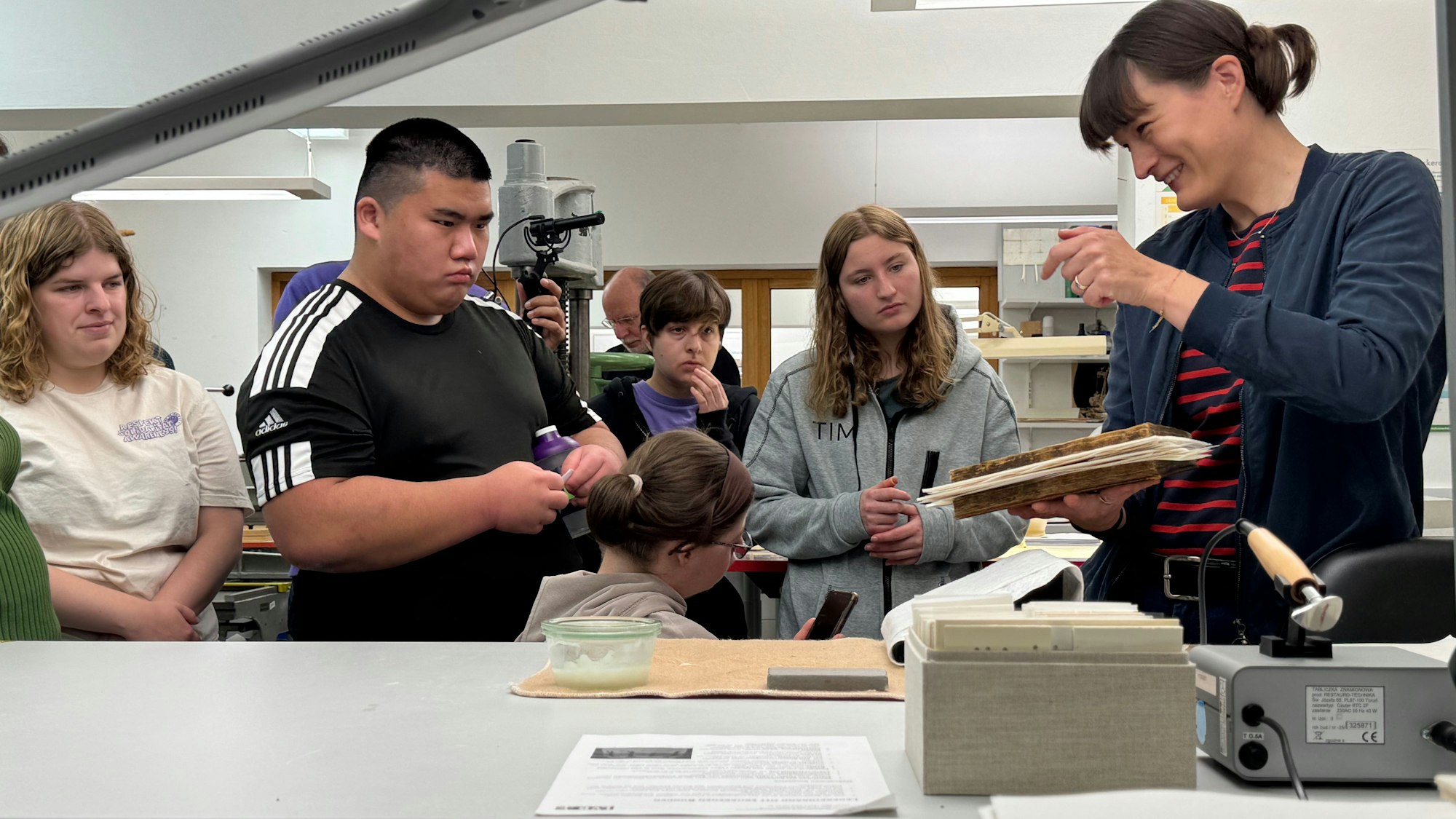 Jugendliche hören einer Frau aufmerksam zu.
