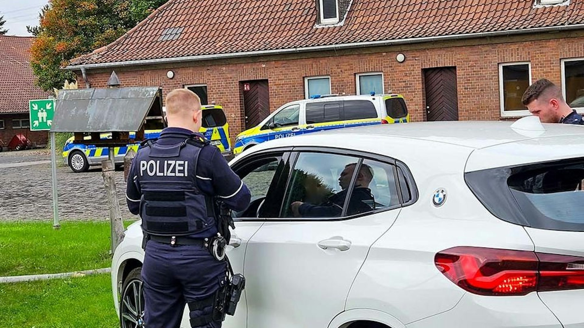 Polizeibeamte bei einer Fahrzeugkontrolle in der Dämmerung.