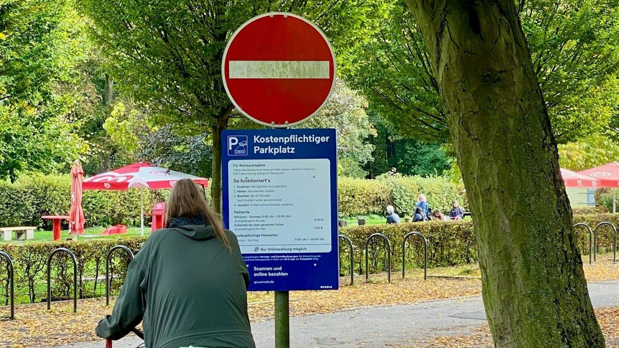 Eine Radlerin studiert die Hinweisschilder der neuen Parkraumbewirtschaftung.