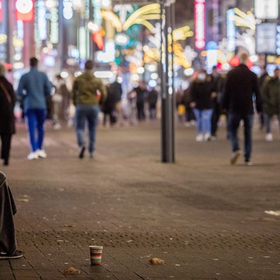 Das Bild zeigt einen in Decken gehüllten Menschen in der Kölner Innenstadt. (Symbolbild)