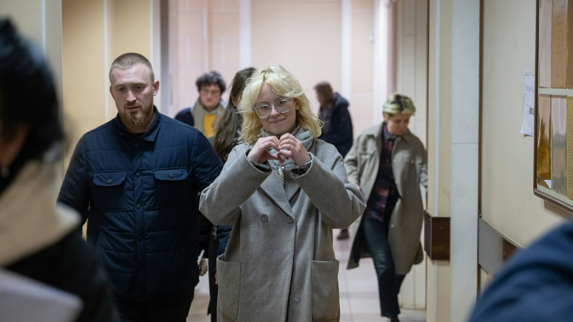 Ein Polizist führt die Sängerin Diana Loginowa (Künstlername Noako) in Handschellen in einen Gerichtssaal in Sankt Petersburg.