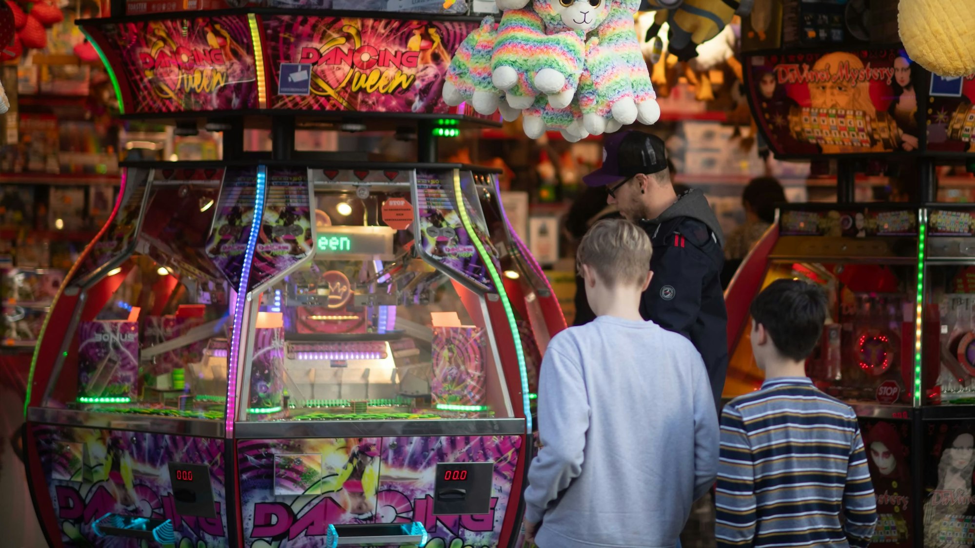 Zwei Kinder stehen vor einem .bunt beleuchteten Kirmesstand