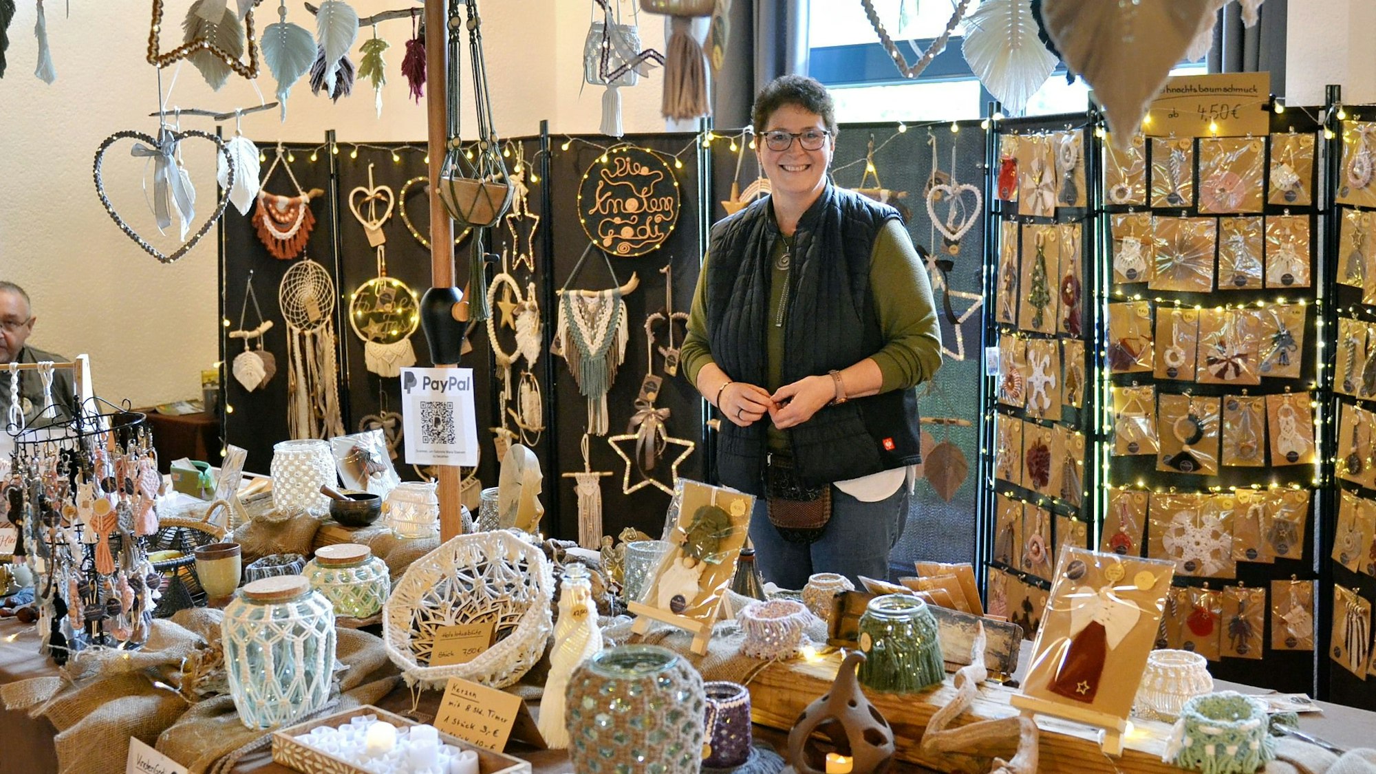 Das Bild zeigt die Obengenannte hinter ihrem Stand beim Handwerkermarkt.