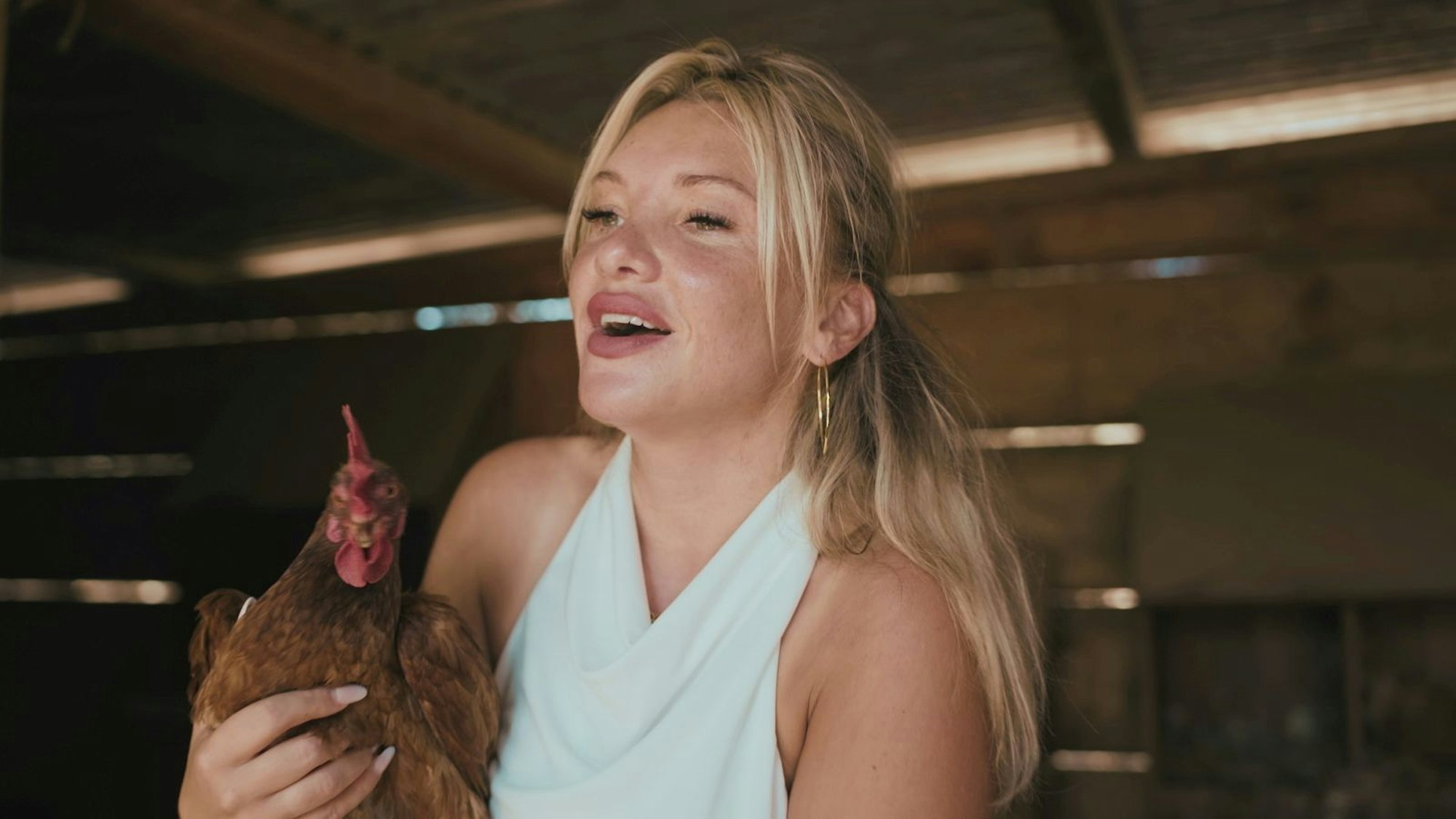 Evelyn Burdecki freut sich mit einem Huhn im Arm. (Bild: Sky/B 28)