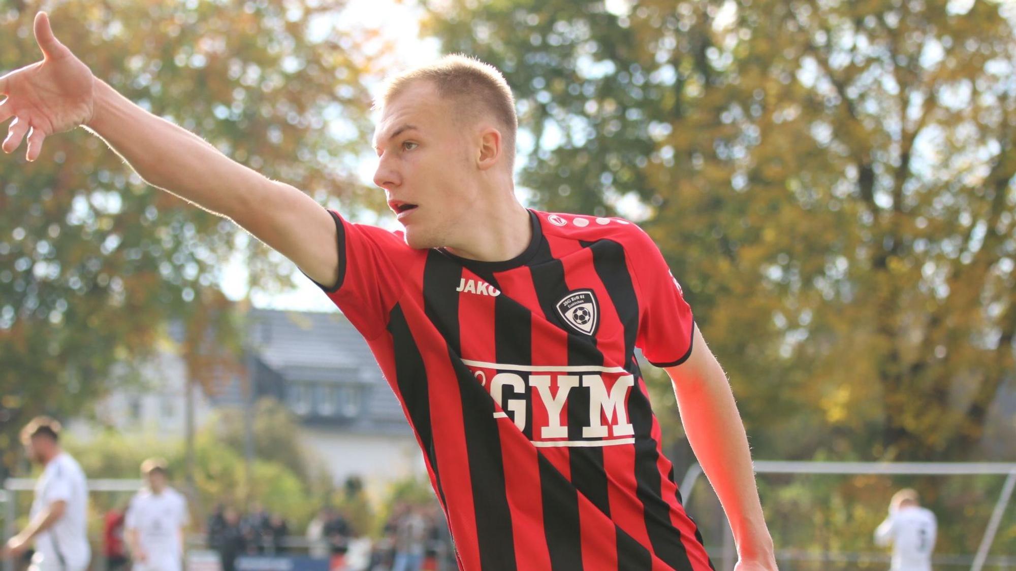 Luke Bungart simuliert beim Torjubel einen Dartwurf.