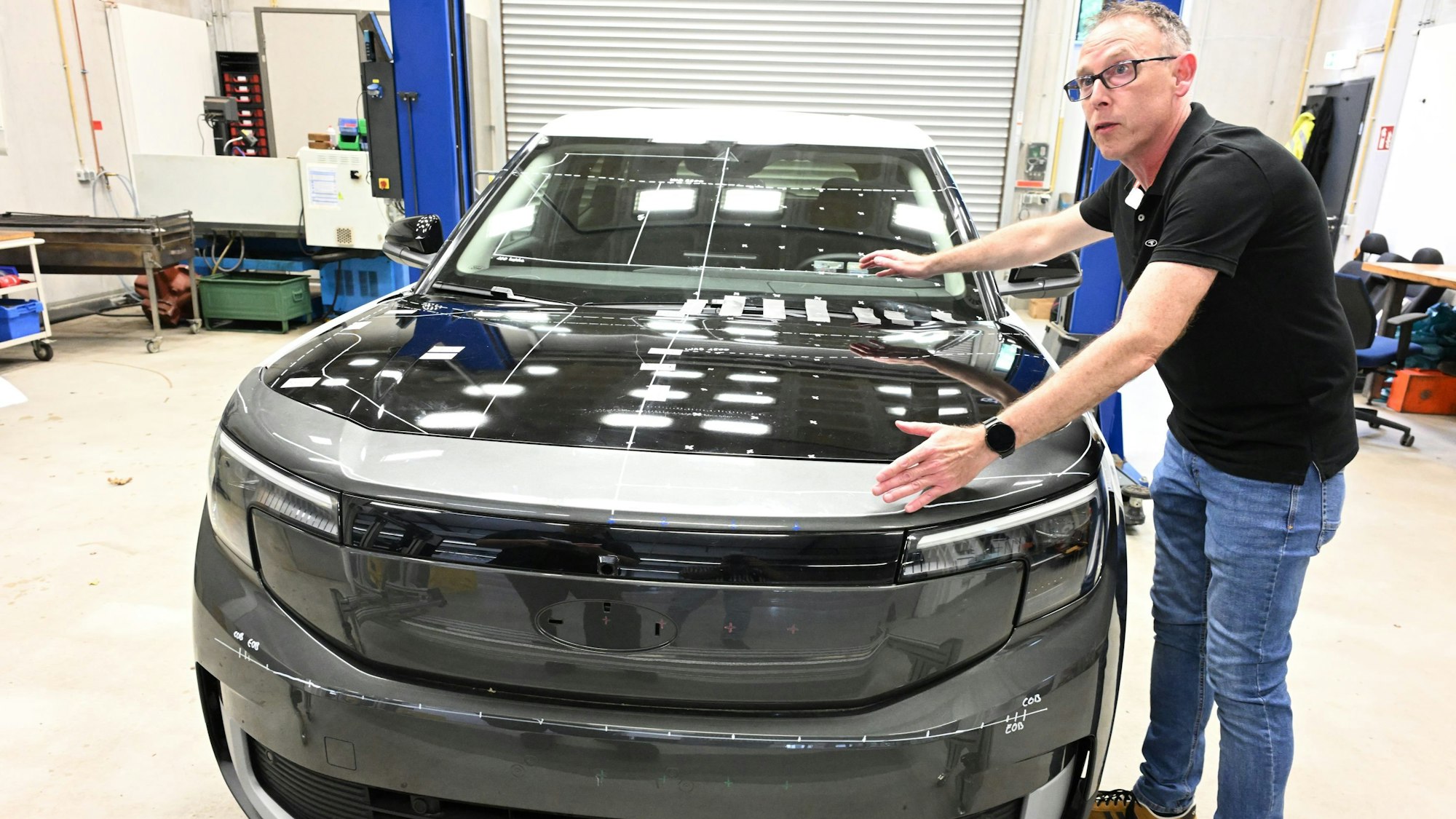 In einer Haller erläutert Oliver Zander von der BASt die Anprallbereiche von Fußgängern und Radfahrern an einem Pkw.