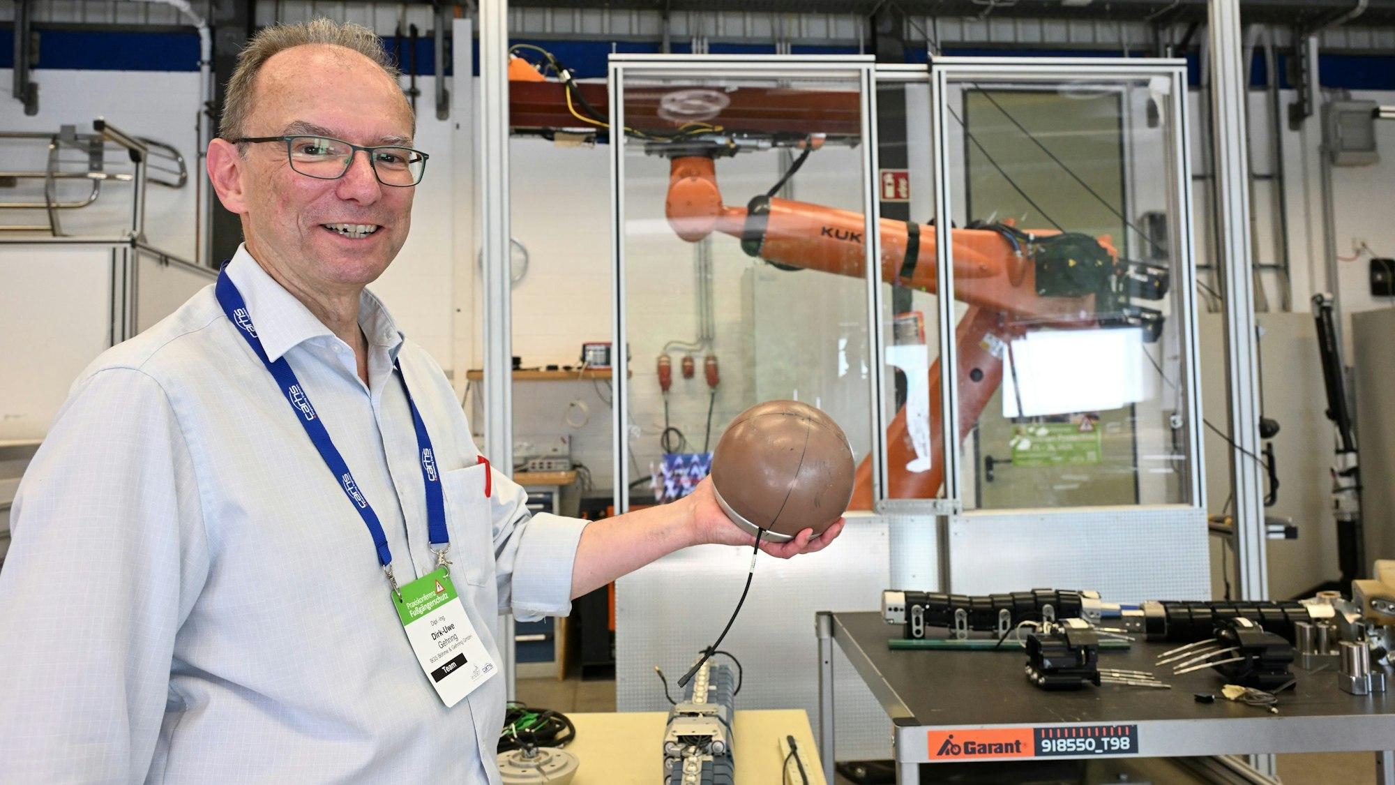 Dirk-Uwe Gehring zeigt eine Kopfnachbildung, mit der sich Aufprallszenarien auf Motorhauben oder Windschutzscheiben simulieren lassen.