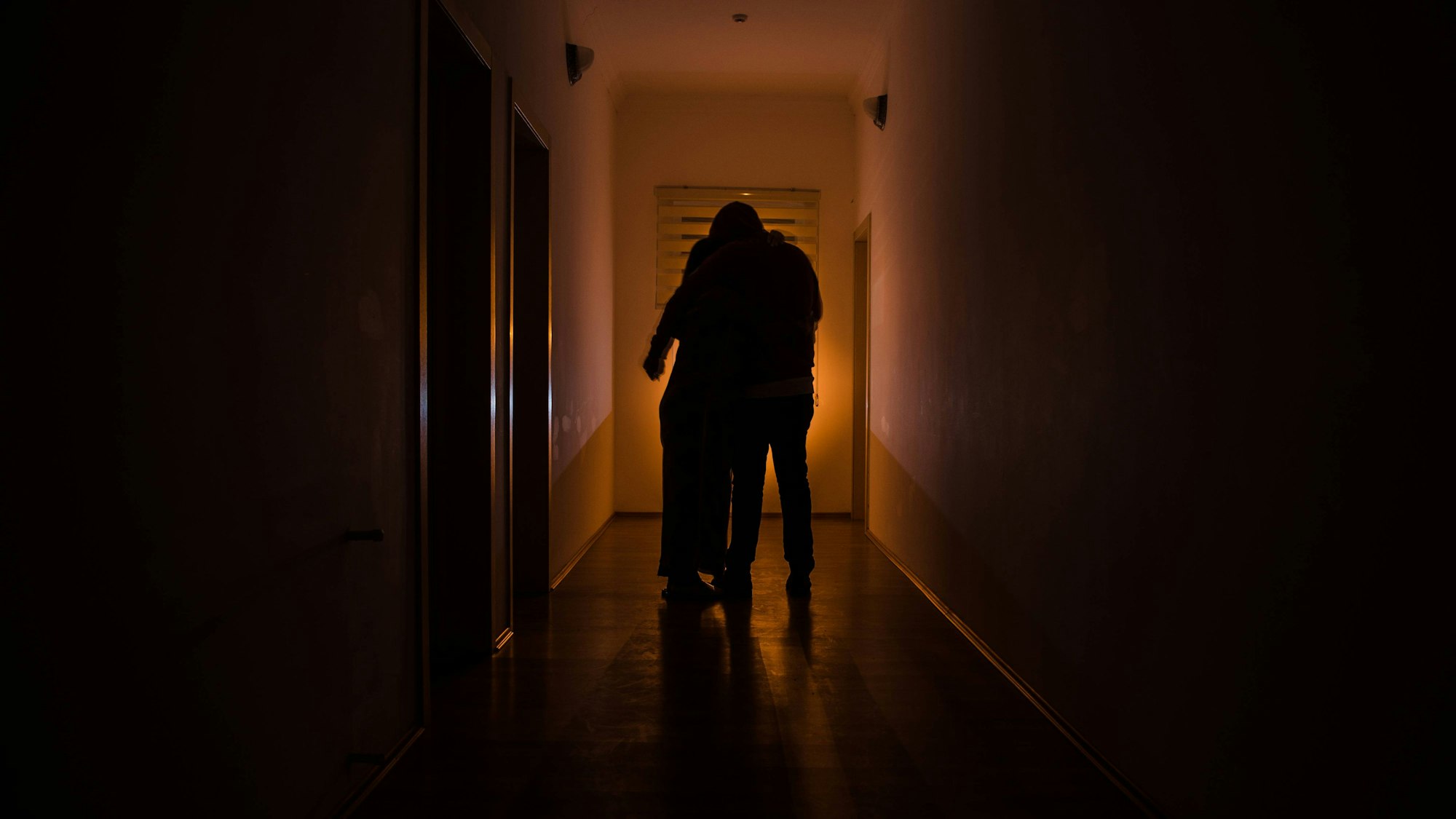 Dunkler Korridor mit Schranktüren und Lichtern mit der Silhouette eines gespenstischen Horror-Mannes, der in verschiedenen Posen steht.