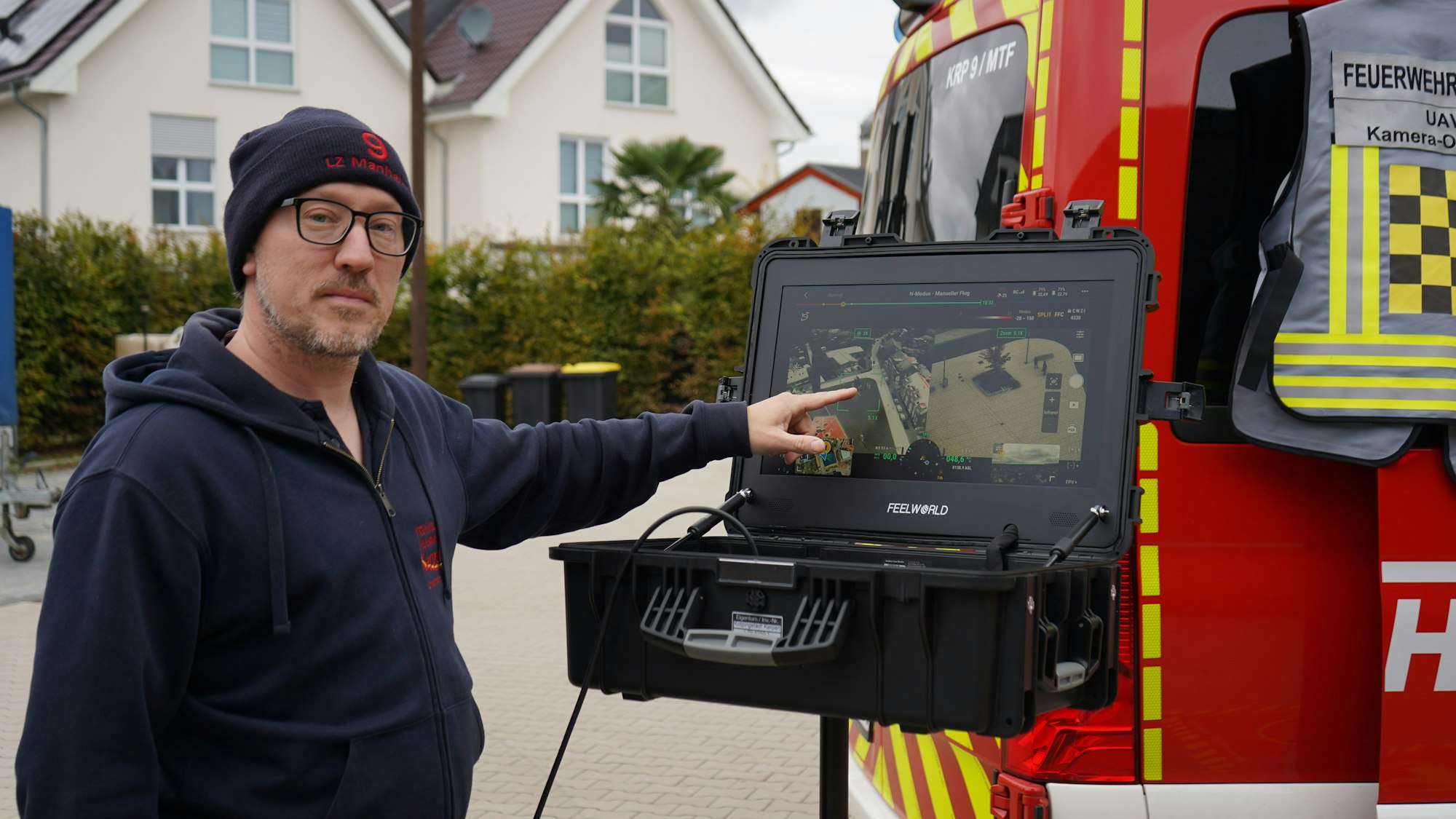 Das Foto zeigt einen Mann, der auf einen Bildschirm zeigt.