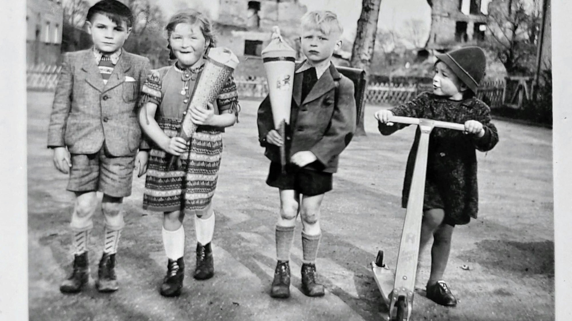 Bild 1: Einschulung März 1951 in die Volksschule Weimarer Straße in Köln Höhenberg. Wir sehen trotz der Häuser in Trümmern im Veedel eigentlich ganz hoffnungsvoll in Erwartung der Schulzeit aus. Die Ruinen im Hintergrund sind die Erfurter Straße.