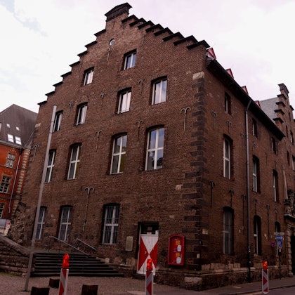 28.07.2025, Köln: Die rot-weißen Fensterläden am Zeughaus, in der Fachsprache Schlagläden genannt, wurden seit Montag abgenommen, weil sie marode sind. Das Gebäude zeigt sich jetzt ohne die Fensterläden. Foto: Thilo Schmülgen