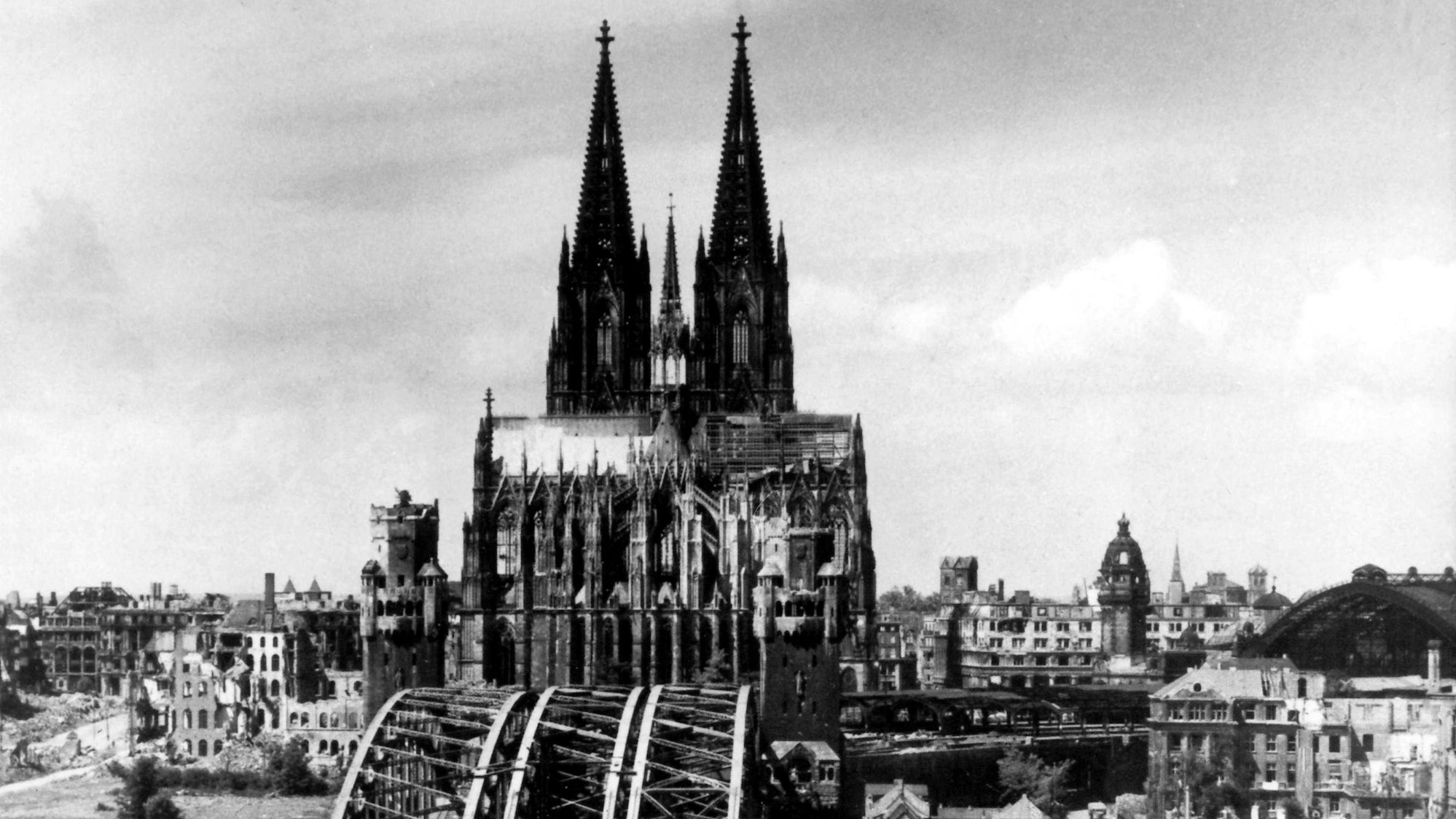 ARCHIV - 01.01.1945, Nordrhein-Westfalen, Köln: Die Aufnahme von 1945 zeigt den Blick auf den Kölner Dom, der als einziges Bauwerk aus den Trümmern der Stadt hervorragt. Vorn die zerstörte Hohenzollernbrücke. (zu dpa: «Als das Inferno verstummte - vor 80 Jahren endete der Zweite Weltkrieg») Foto: -/dpa +++ dpa-Bildfunk +++