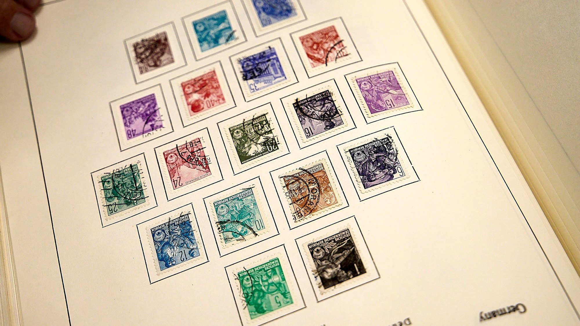 Auf einem Blatt kleben mehrere bunte Briefmarken.