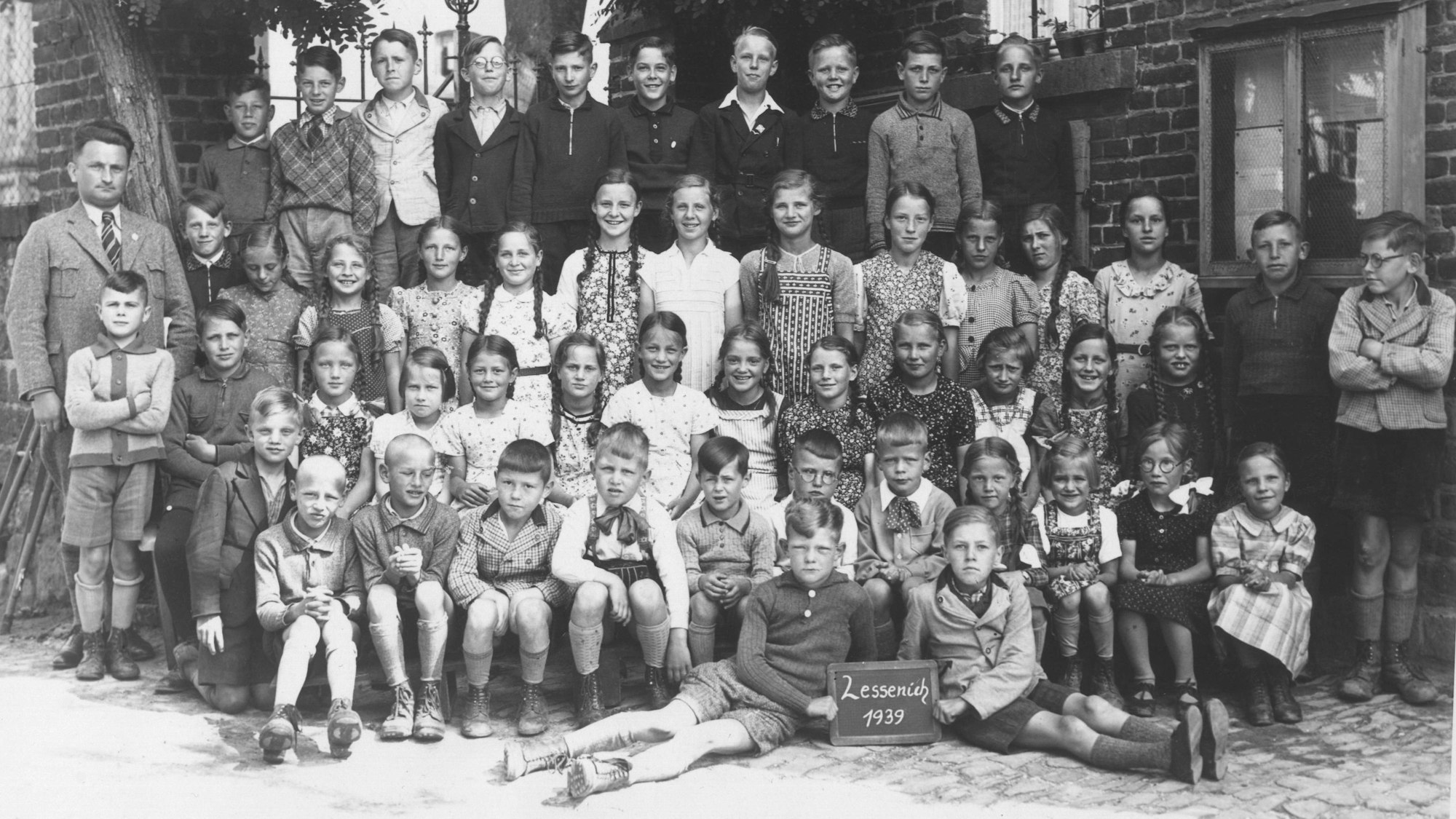 Schulkinder und Lehrer haben sich zu einem Gruppenbild aufgestellt.