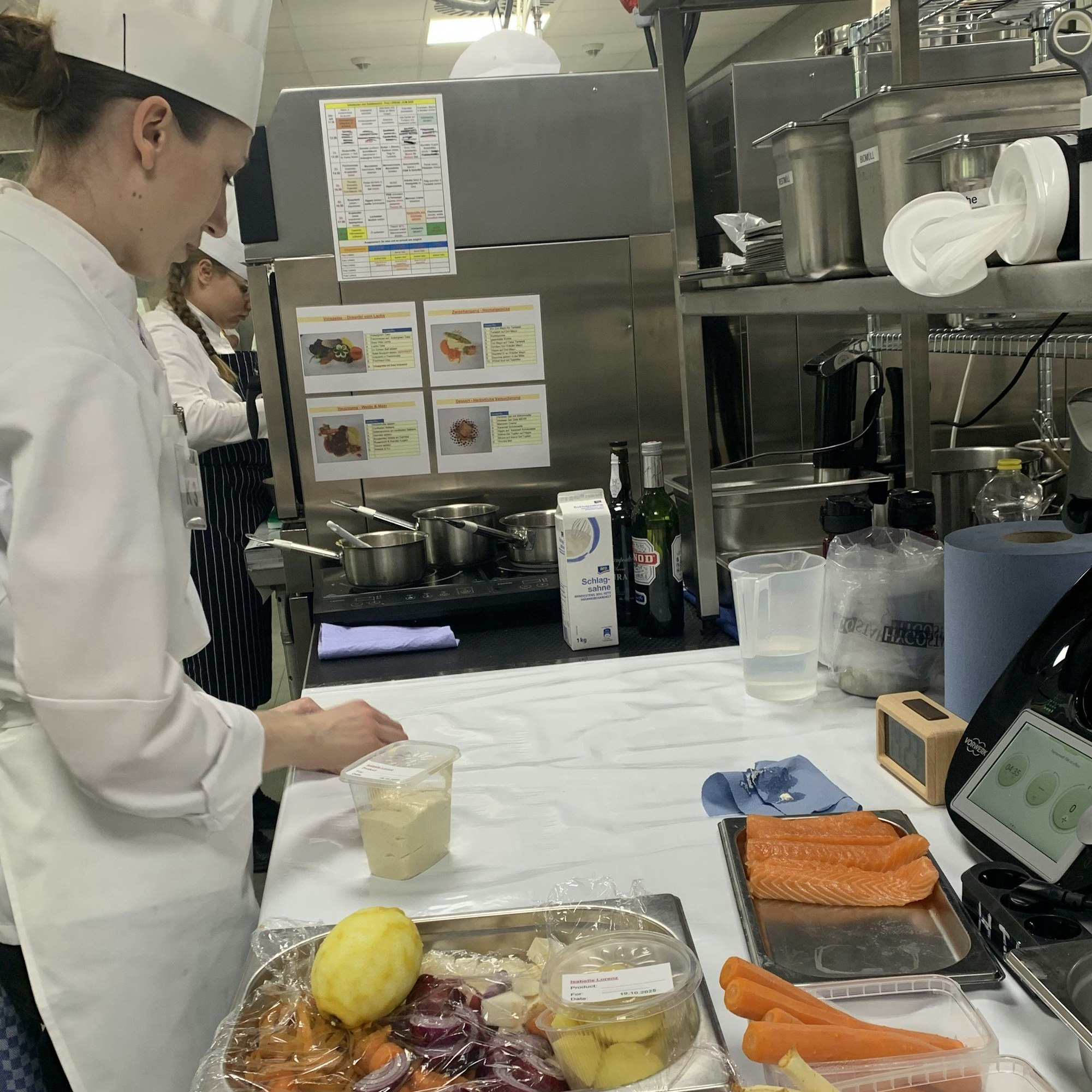 Eine Köchin mit Speisen, die auf die Zubereitung warten.