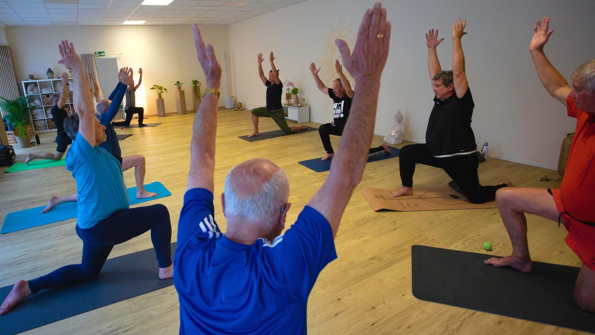 Zu sehen ist eine Männergruppe beim Yoga.