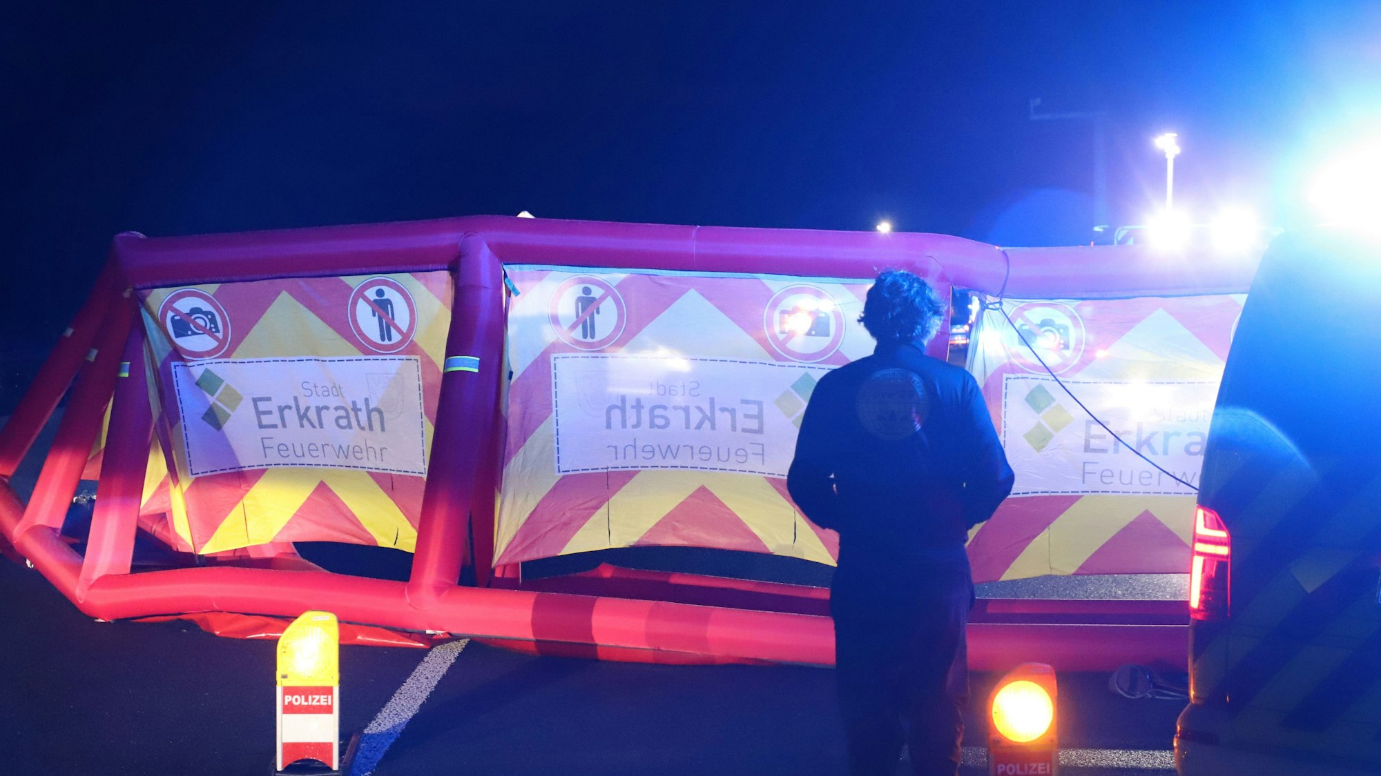 Eine Person steht vor einer aufgestellten Sichtschutzwand nach einem tödlichen Unfall auf der A3 bei Stindertal.