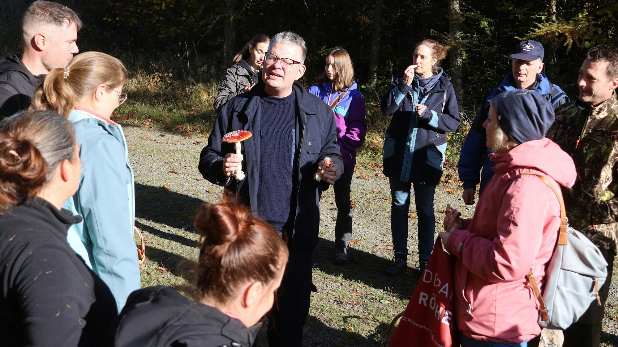 Bestimmungspause im Wald: Daniel Frank erklärt Pilzsammlerinnen und Pilzsammlern in der Nähe des Reichshofer Blockhauses, warum sie vom roten Fliegenpilz tunlichst die Finger lassen sollten.