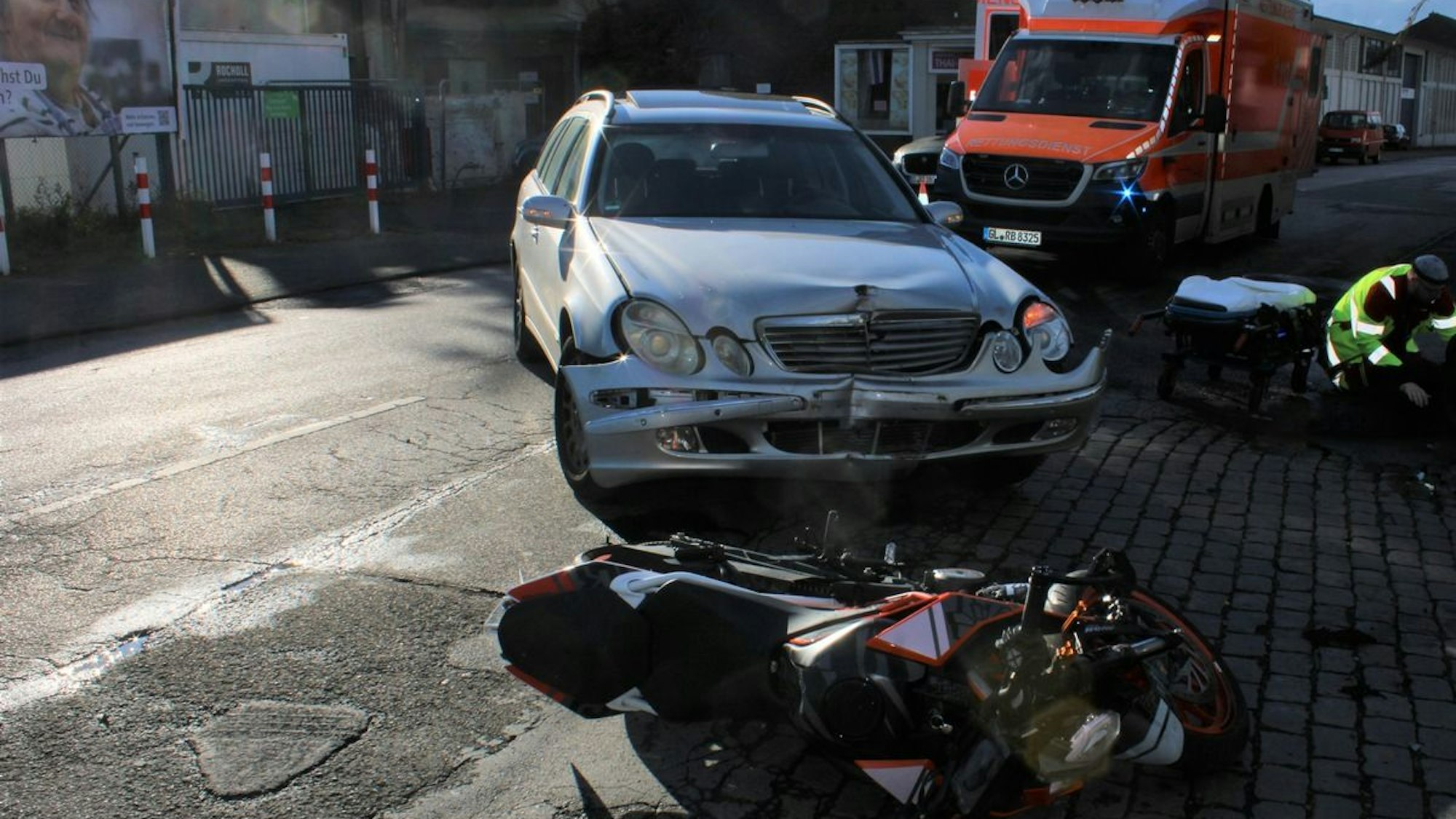 Ein Motorrad und ein Auto sind auf einer Straße zu sehen, die auf einen Unfall hindeuten.