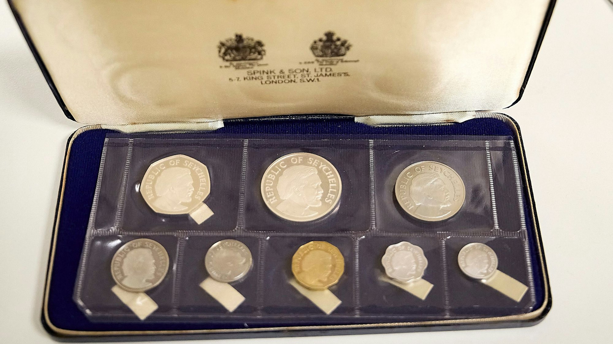 In einer schmalen Schatulle liegen acht Münzen von den Seychellen.