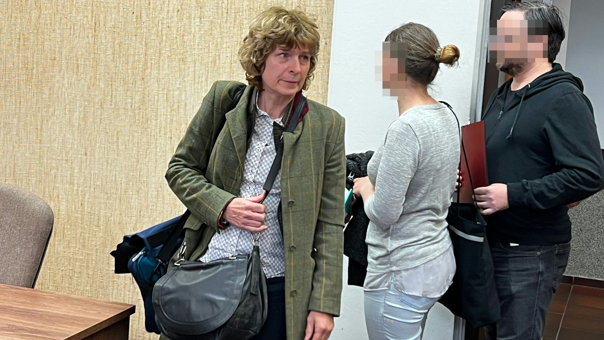 Ein Leverkusener Ehepaar steht vorm Landgericht, weil die Frau kinderpornografische Aufnahmen für den Täter gemacht hatte. Hier sieht man sie beim Prozessauftakt mit der Anwältin Iris Stuff. (l).