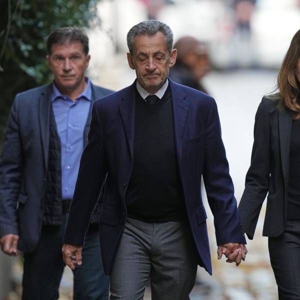 Nicolas Sarkozy und seine Frau Carla Bruni-Sarkozy gehen Hand in Hand die Straße runter.