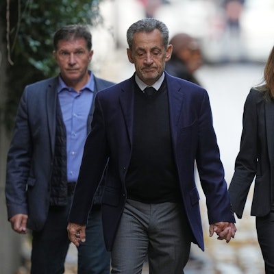 Nicolas Sarkozy und seine Frau Carla Bruni-Sarkozy gehen Hand in Hand die Straße runter.