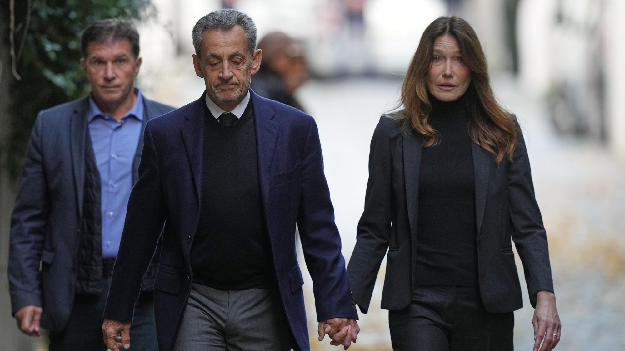 Nicolas Sarkozy und seine Frau Carla Bruni-Sarkozy gehen Hand in Hand die Straße runter.