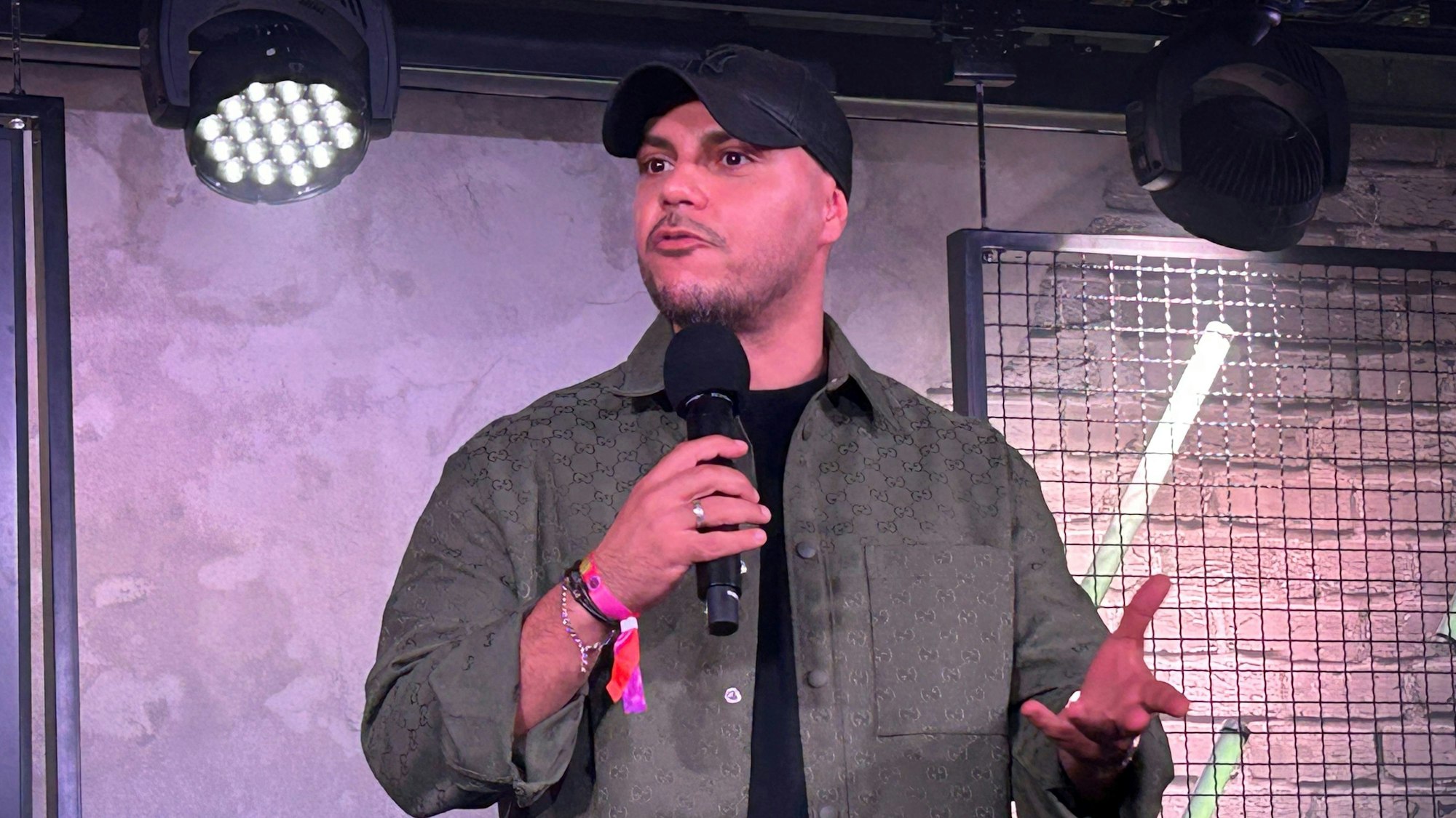 Comedian Osan Yaran steht auf der Bühne.