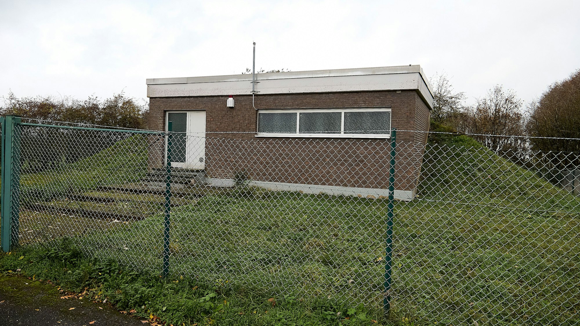 Hinter einem Maschendrahtzaun ist das Gebäude des Trinkwasser-Hochbehälters in Nettersheim-Tondorf zu sehen.