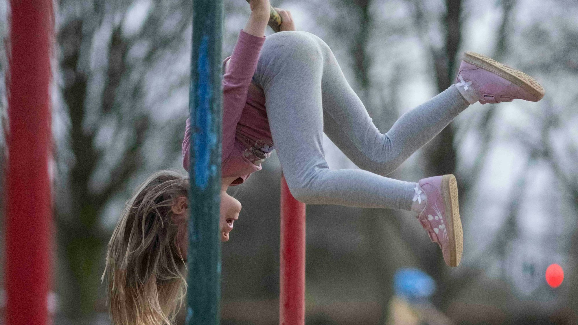 Ein Kind hängt kopfüber an einer Drehstange auf dem Spielplatz am Schillerpark in Euskirchen.