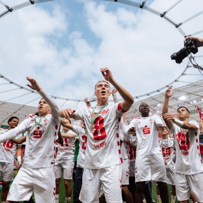 Nick Zimmermann (M.) feiert mit seinen Teamkollegen vom 1. FC Köln den Gewinn der Meisterschaft.