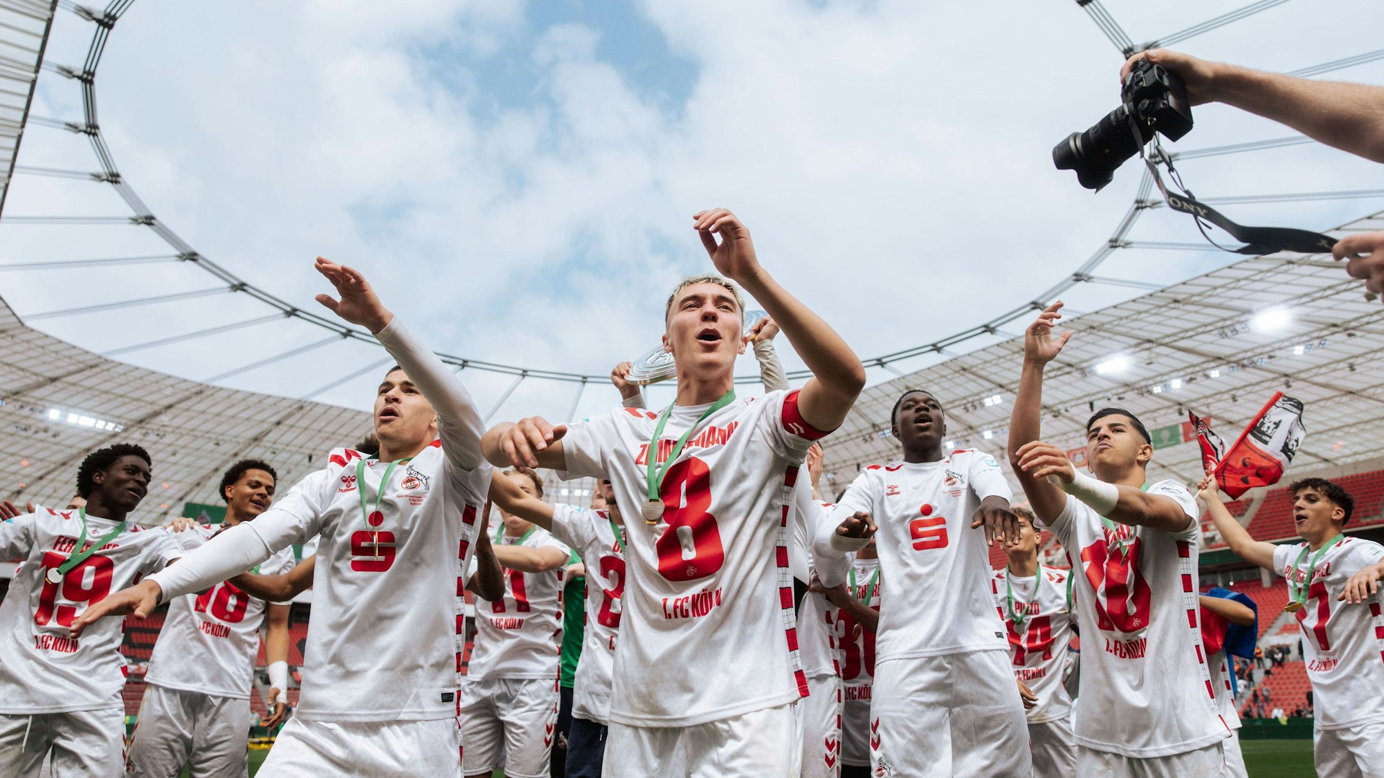 Nick Zimmermann (M.) feiert mit seinen Teamkollegen vom 1. FC Köln den Gewinn der Meisterschaft.