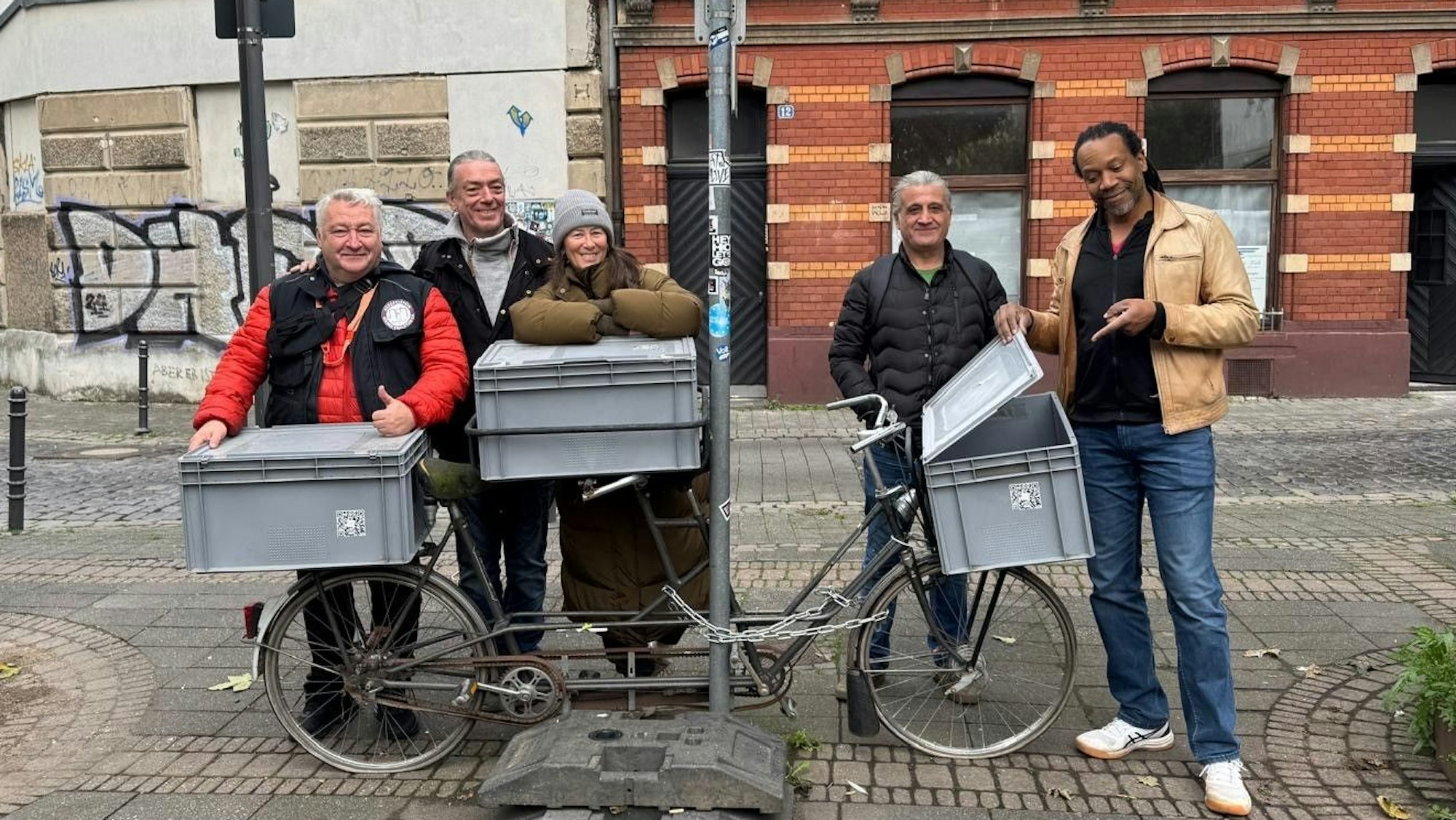 Eine Frau umarmt eine große Kiste, die auf einem Fahrrad steht.