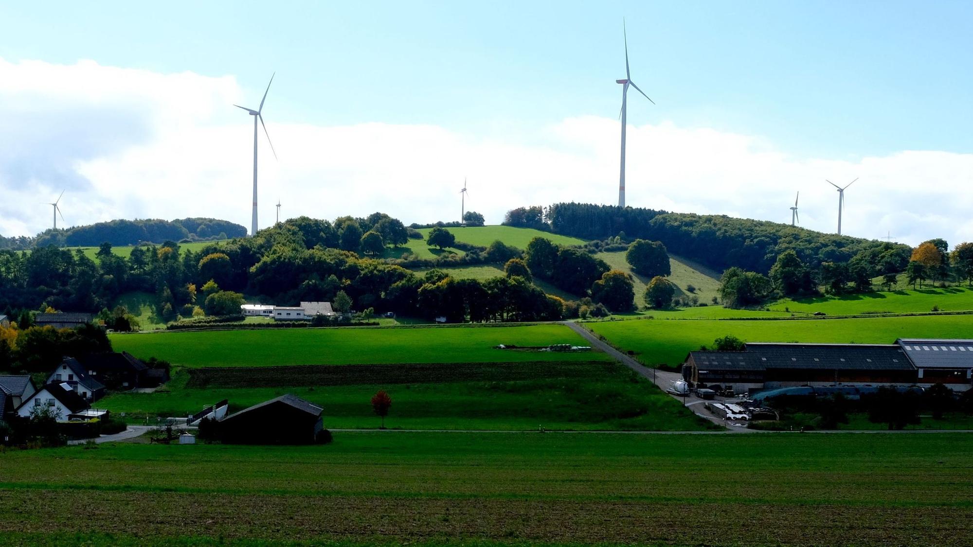 Blick über Wiesen und Felder von Kallmuth auf den Windpark am Ravelsberg.