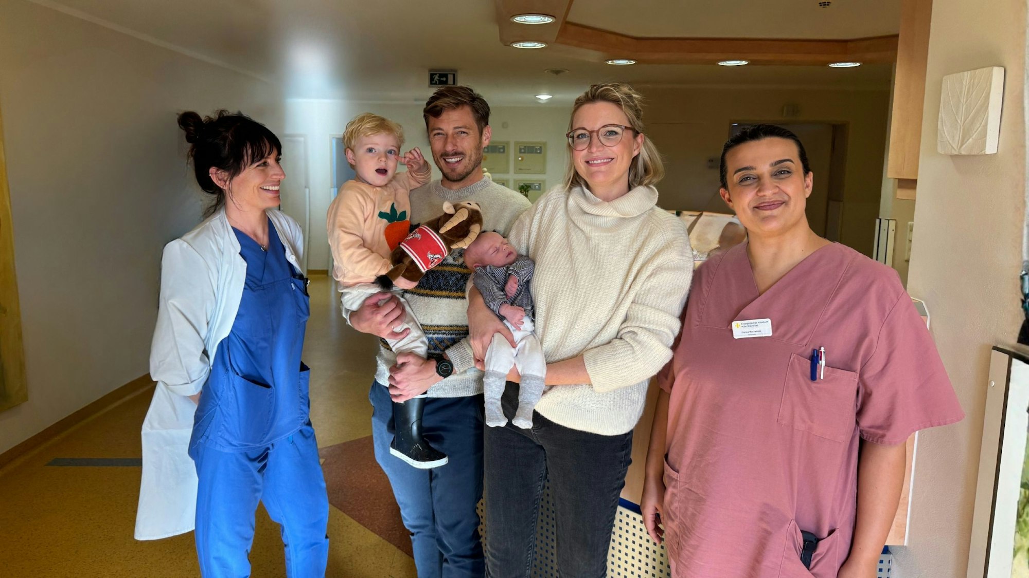 Das Bild zeigt die Familie Mack sowie Oberärztin Birke Bauer und Hebamme Fiorina Maccarone.