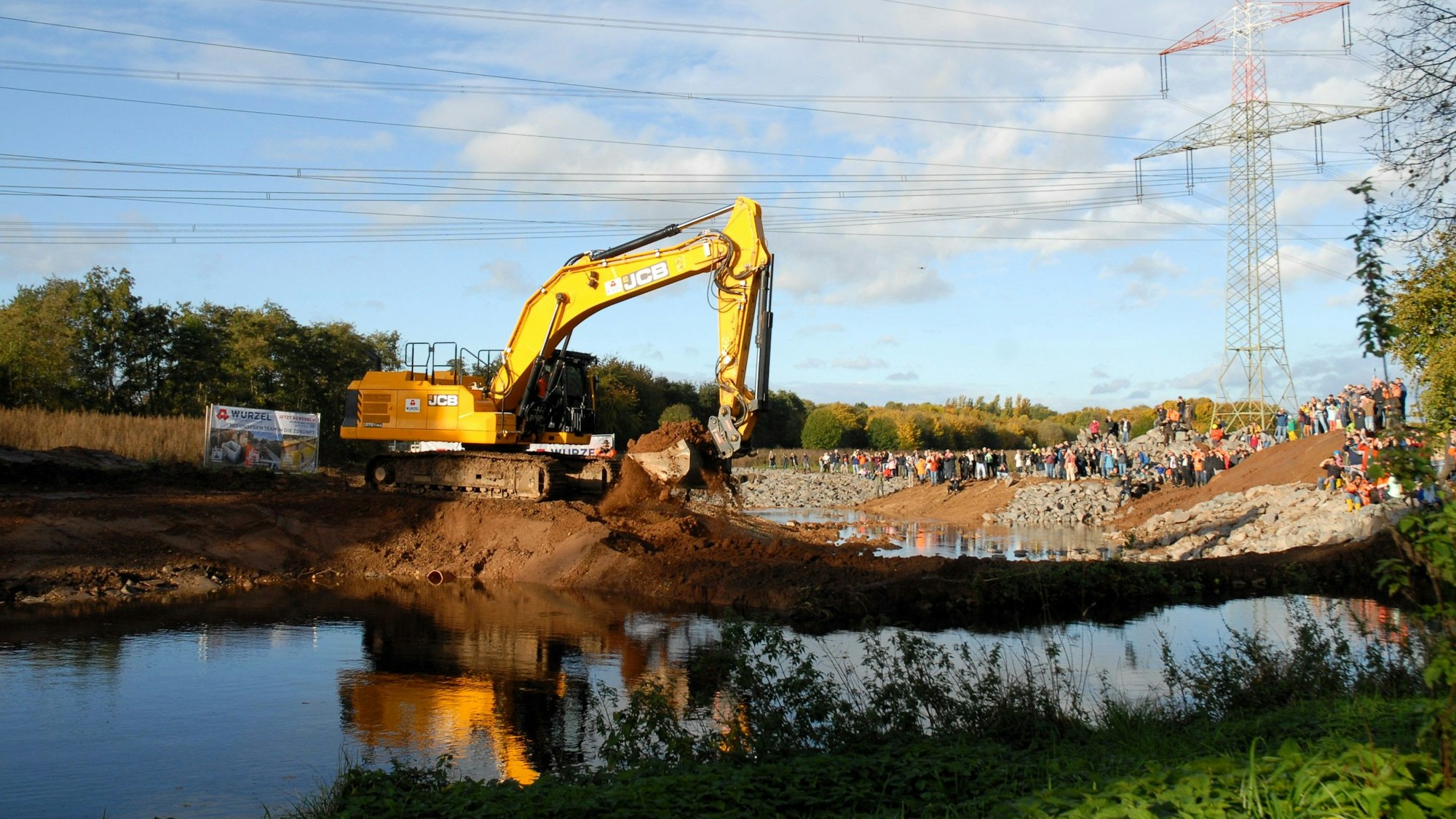 Ein Bagger baggert ein Flussbett frei.