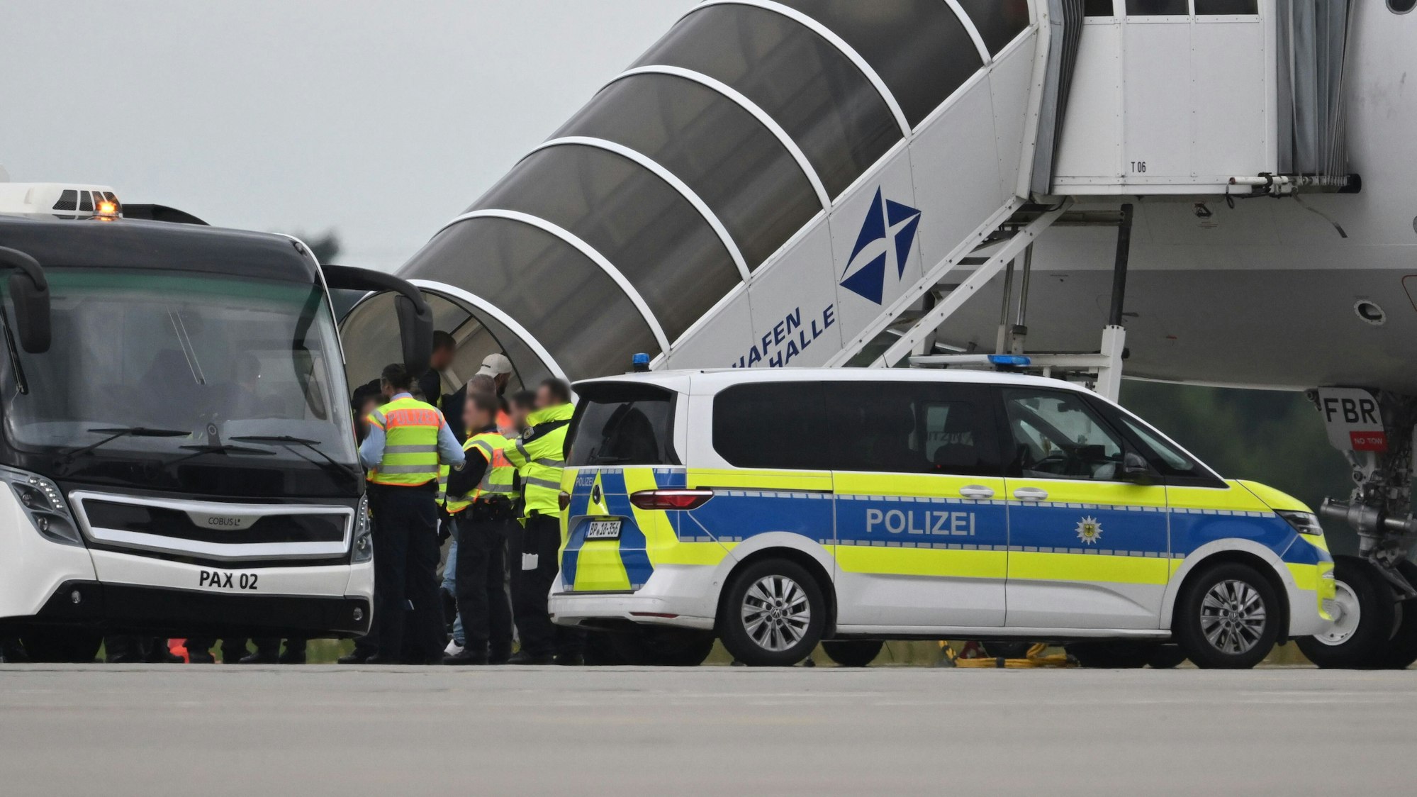 Ein Abschiebeflug vom Flughafen Leipzig/Halle, vor dem Flieger stehen Polizeibeamte.