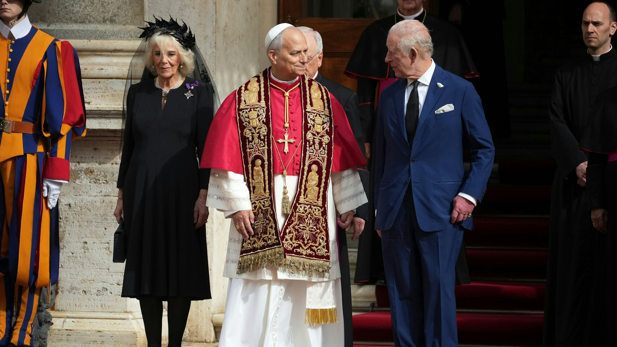Papst Leo XIV. (M) steht neben dem britischen König Charles III. (r) und Königin Camilla im Hof von St. Damasus im Vatikan zum Abschluss des Staatsbesuchs.