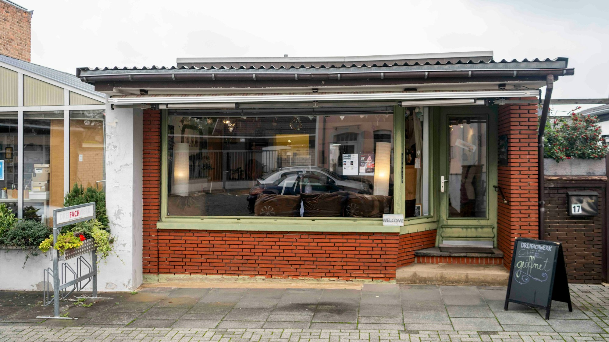 Hinter der Fassade des früheren Blumenladens in Euskirchen-Stotzheim mit dem grün gerahmten Schaufenster ist heute ein Café.