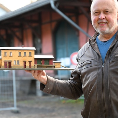 Bürgermeister Gero Karthaus präsentiert vor dem Original ein Modell des Ründerother Bahnhofs, das ein Engelskirchener Bürger in den 1950er Jahren angefertigt hatte.