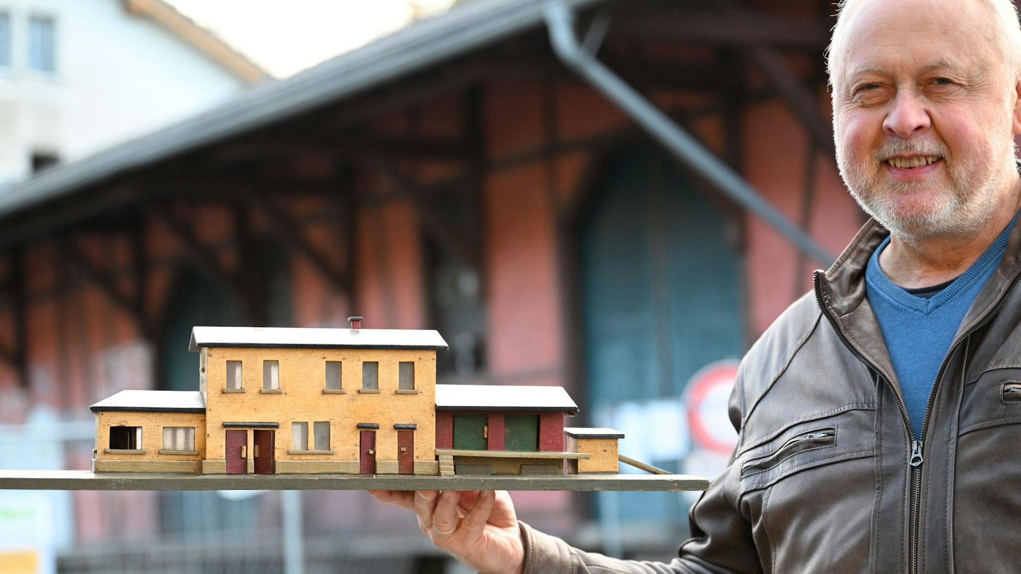 Bürgermeister Gero Karthaus präsentiert vor dem Original ein Modell des Ründerother Bahnhofs, das ein Engelskirchener Bürger in den 1950er Jahren angefertigt hatte.