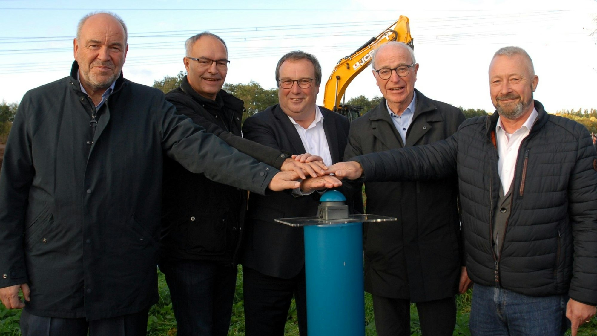 Fünf Männer stehen nebeneinander und drücken auf einen Buzzer.