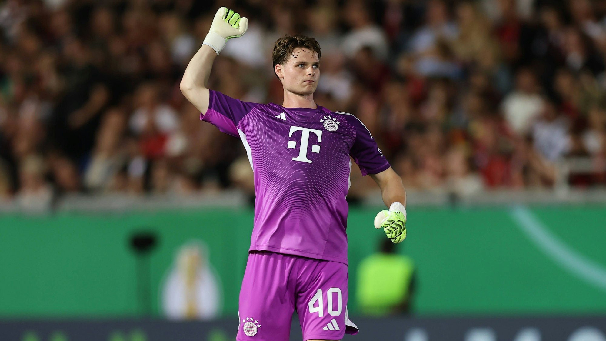 Jonas Urbig im Trikot des FC Bayern auf dem Platz.