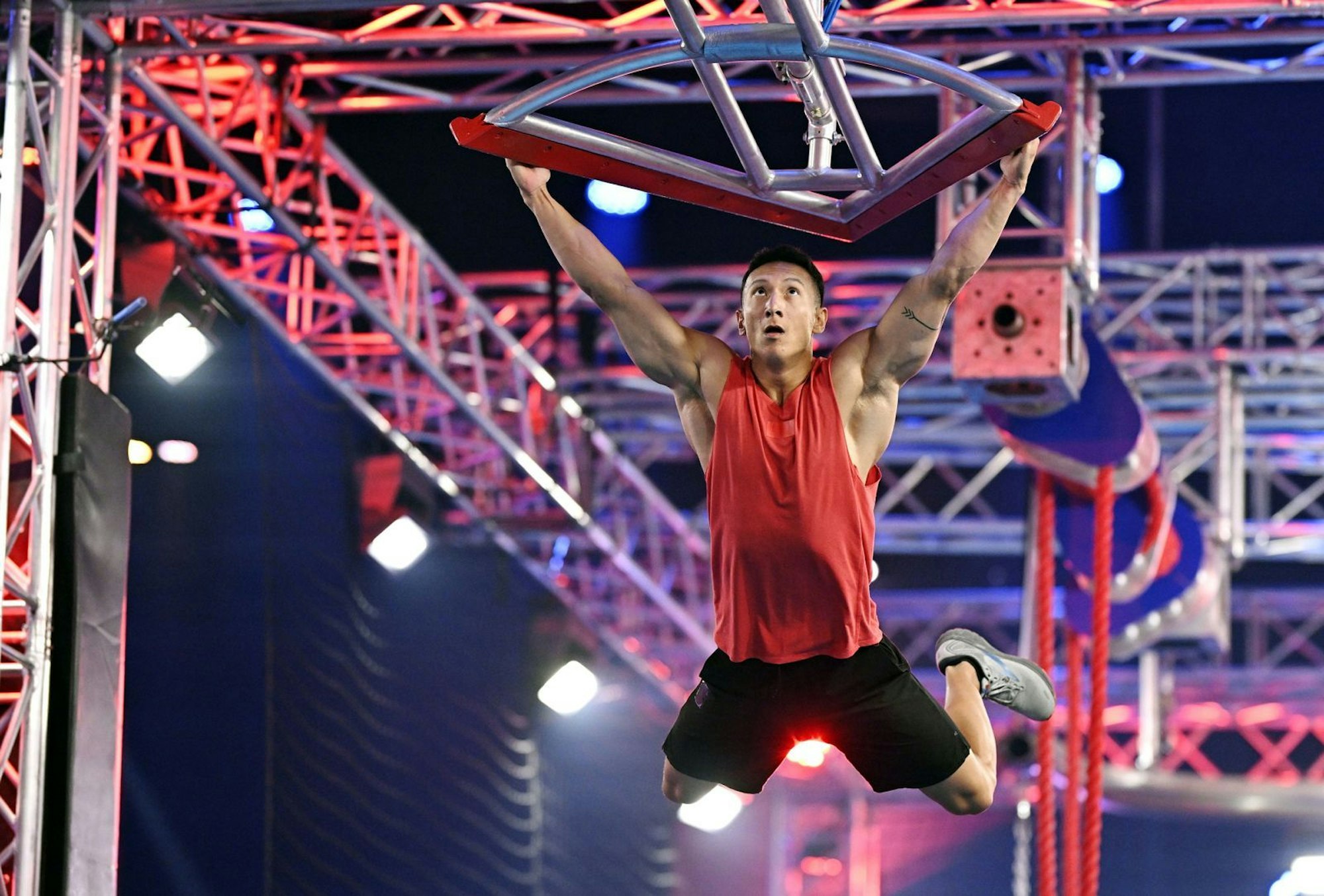 Dieses Hindernis, an dem sich hier David Wollschläger abmüht, heißt „Buschis Rache“. Es ist ein Denkmal für Frank Buschmann, der seine letzte Staffel als Moderator von „Ninja Warrior Germany“ (RTL) bestreitet. Zur Einweihung gibt's Schampus-Dusche. Buschi ist gerührt: „Das geht unter die Haut.“ Dann feixt er: „Da fliegt ihr alle rein, ihr Pflaumen.“ (Bild: RTL/Markus Hertrich)