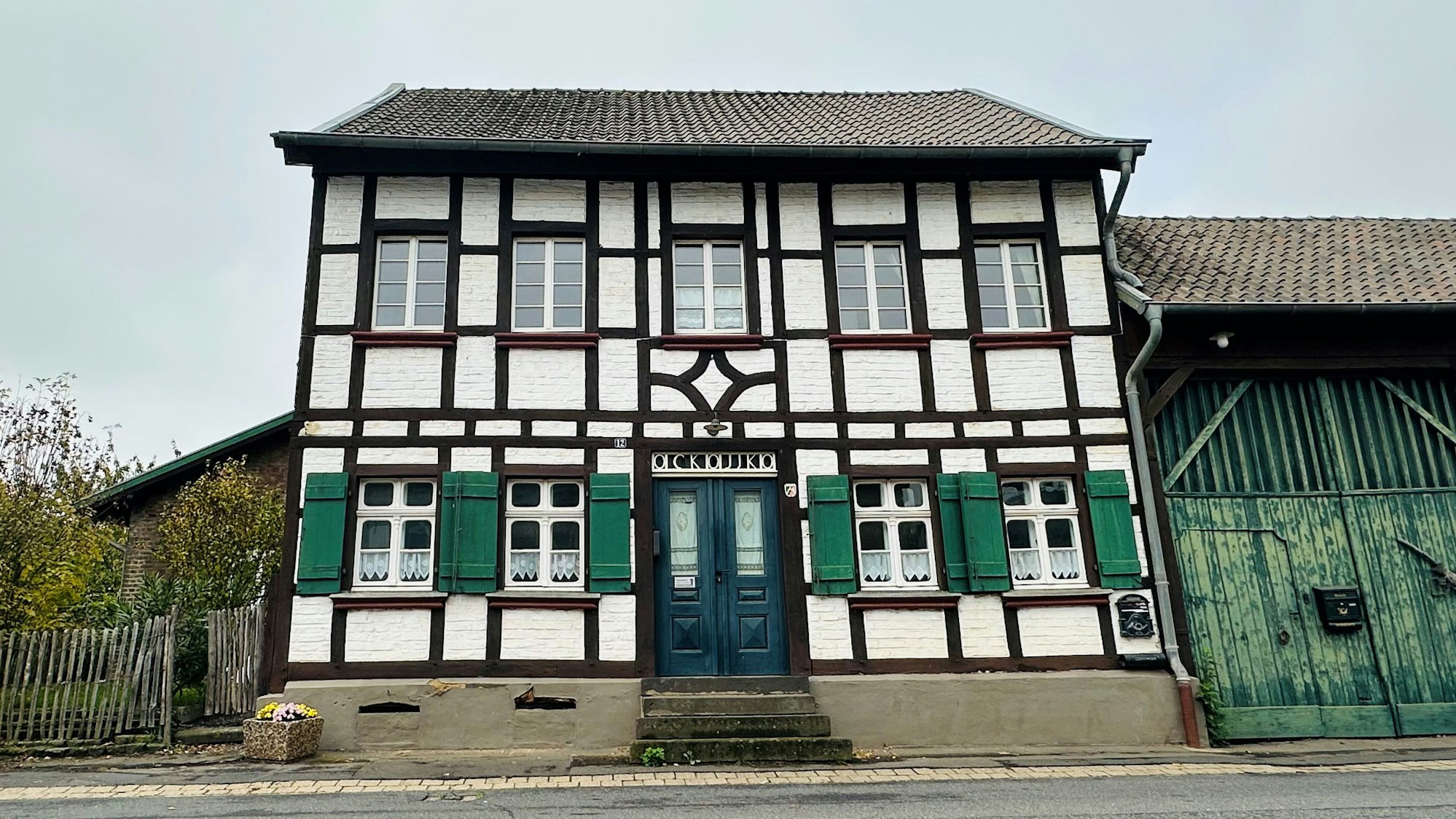 Das Bild zeigt ein Fachwerkhaus an einer Straße.