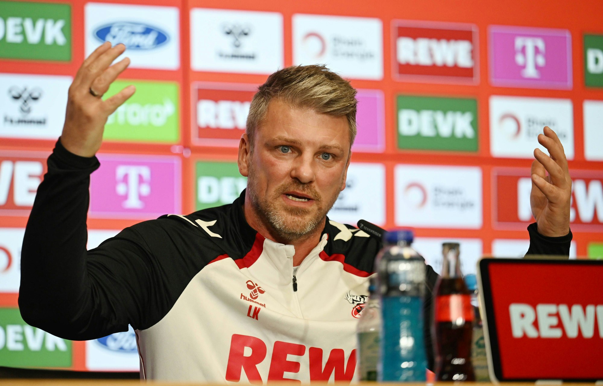 Trainer Lukas Kwasniok vom 1. FC Köln gestikuliert auf einer Pressekonferenz.