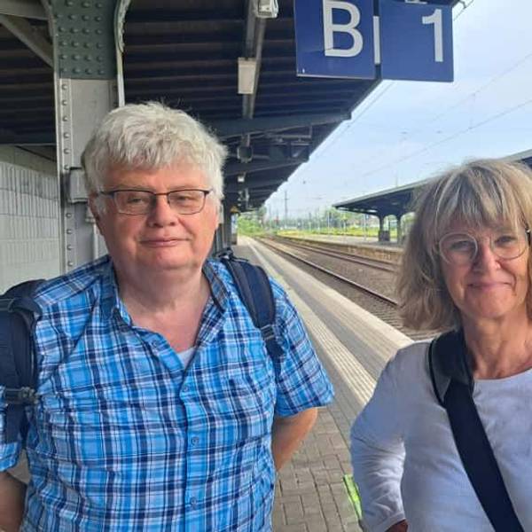 Eine Frau und ein Mann stehen auf einem Bahnsteig.