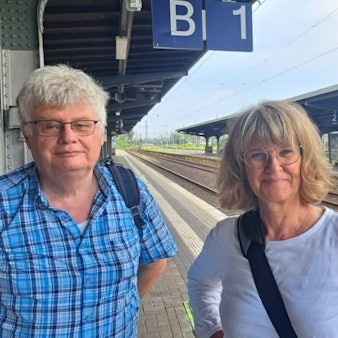 Eine Frau und ein Mann stehen auf einem Bahnsteig.